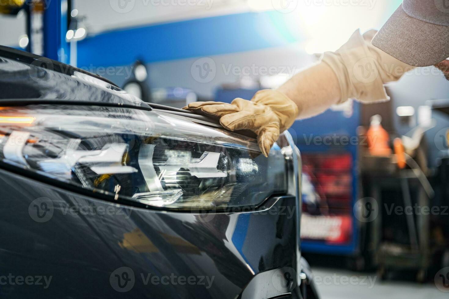 Auto Service Technician Checking on a Car Headlight photo