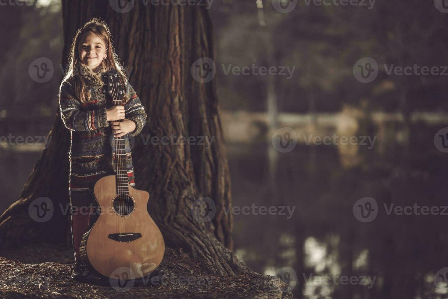 niña con guitarra en el parque foto