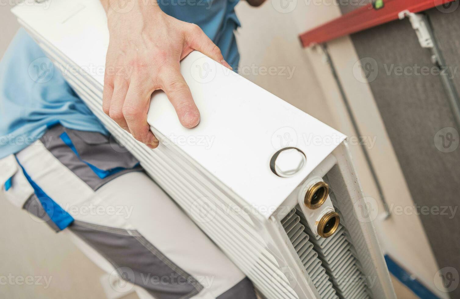 HVAC Worker Installing Residential Heating Radiator photo