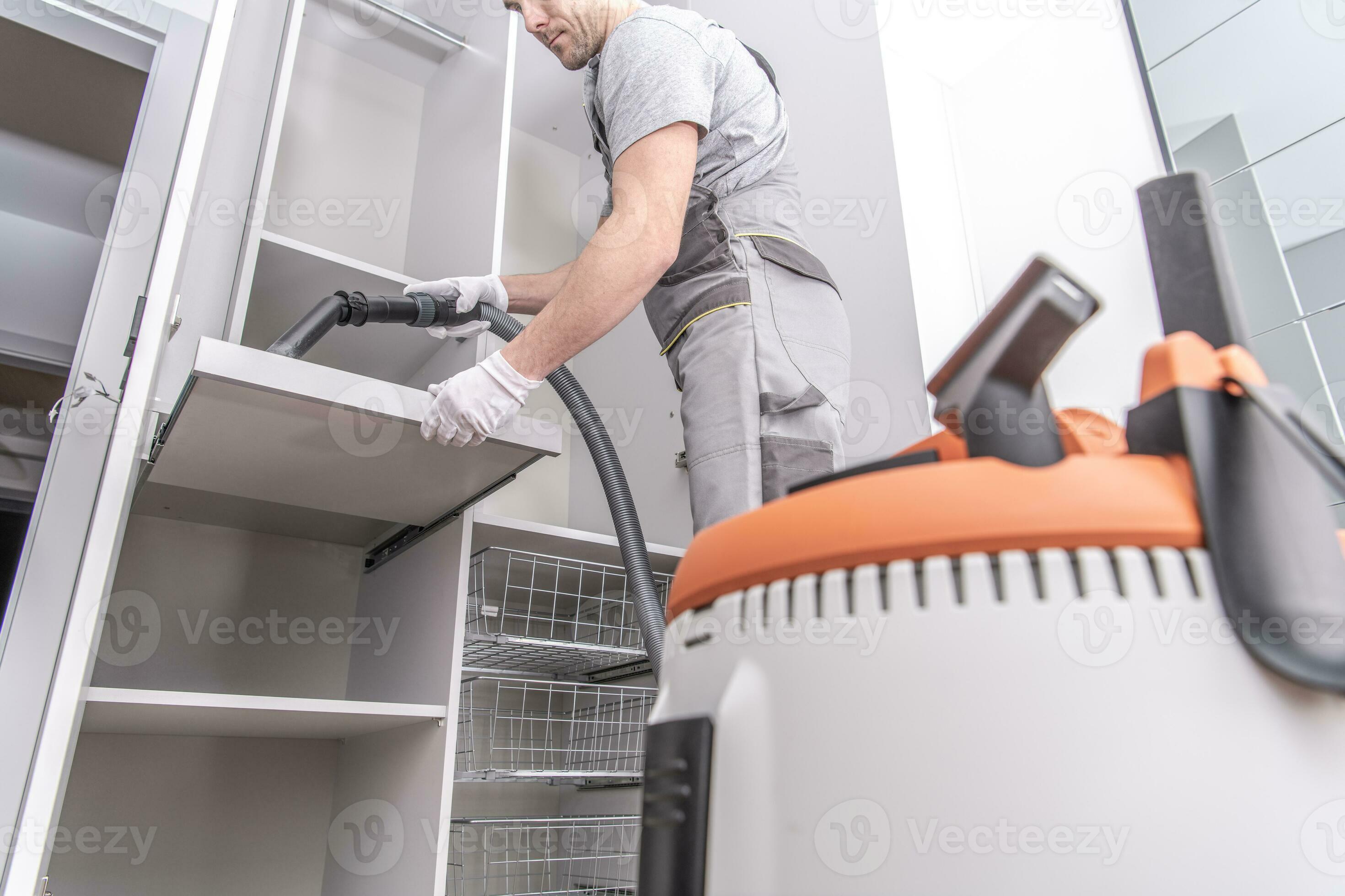 Handyman Cleaning Freshly Installed Wardrobe with Vacuum Cleaner