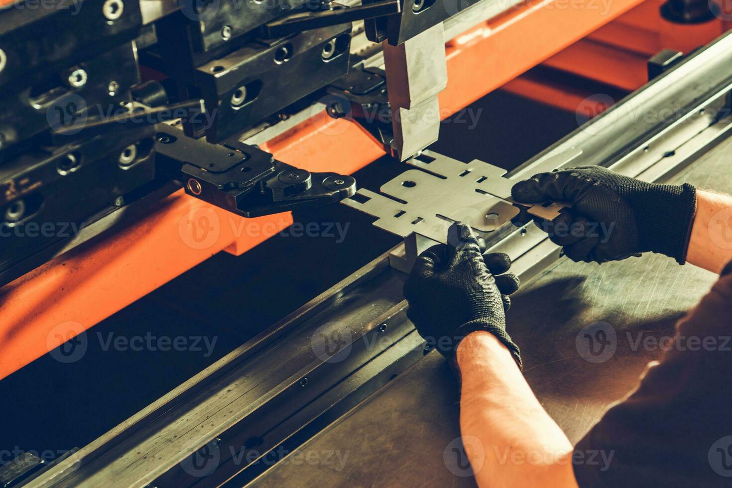 Metalworking Professional Worker Folding Piece of Metal Element Using Powerful Automatic Metal Bending Machine photo