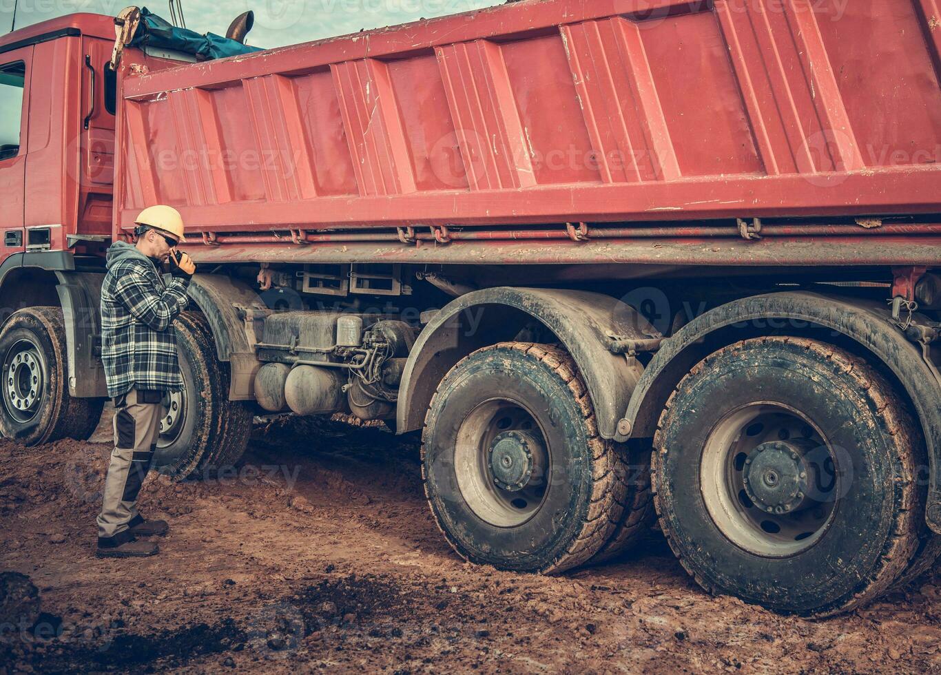 Male Dump Truck Operator Talks To Workers On Radio. photo