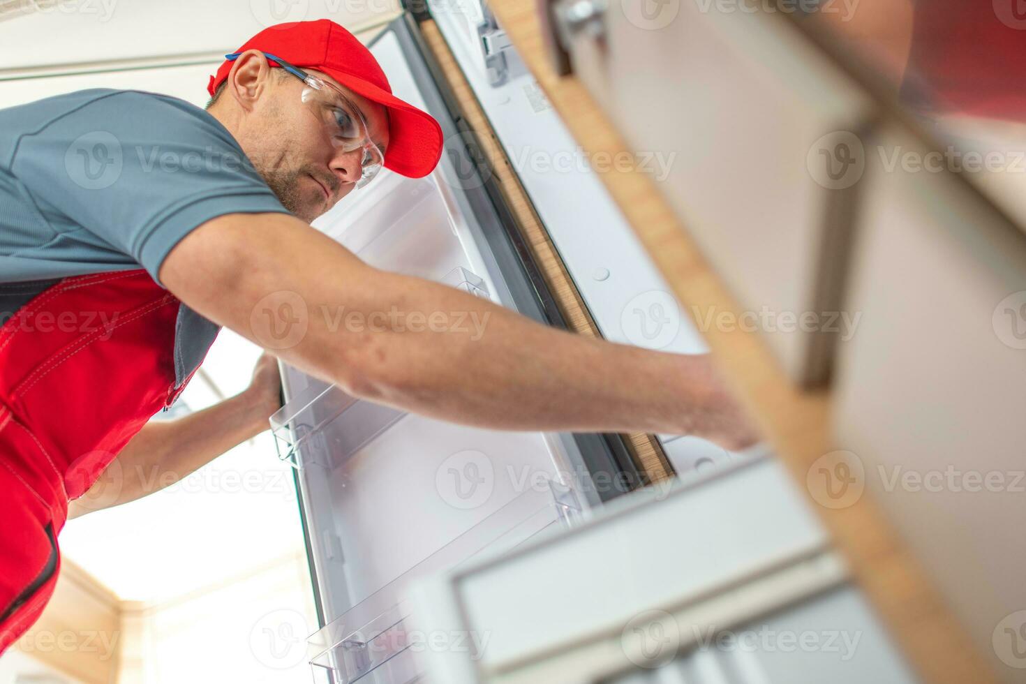 RV Technician Looking Inside Camper Refrigerator photo