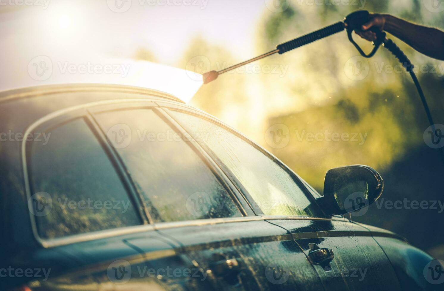 Close Up Of Man Washing Car With Hose. photo