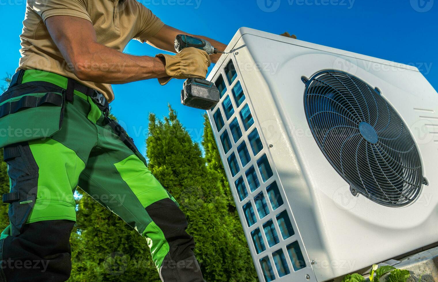 HVAC Technician Installing Large Modern Heat Pump photo