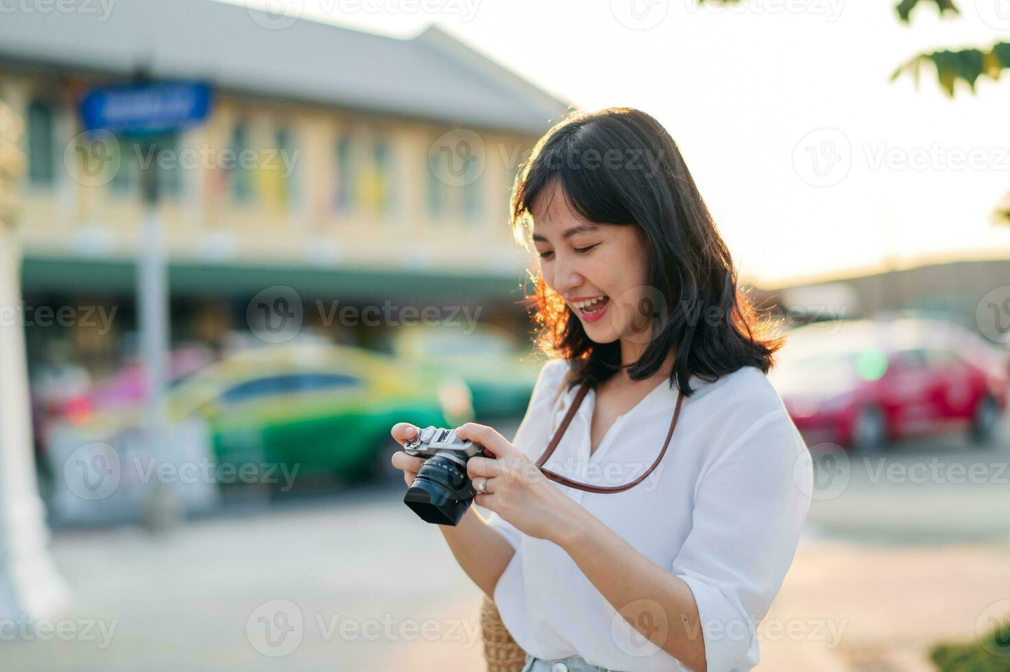 Portrait of asian woman traveler using camera at street of Bangkok, Thailand. Asia summer tourism vacation concept photo