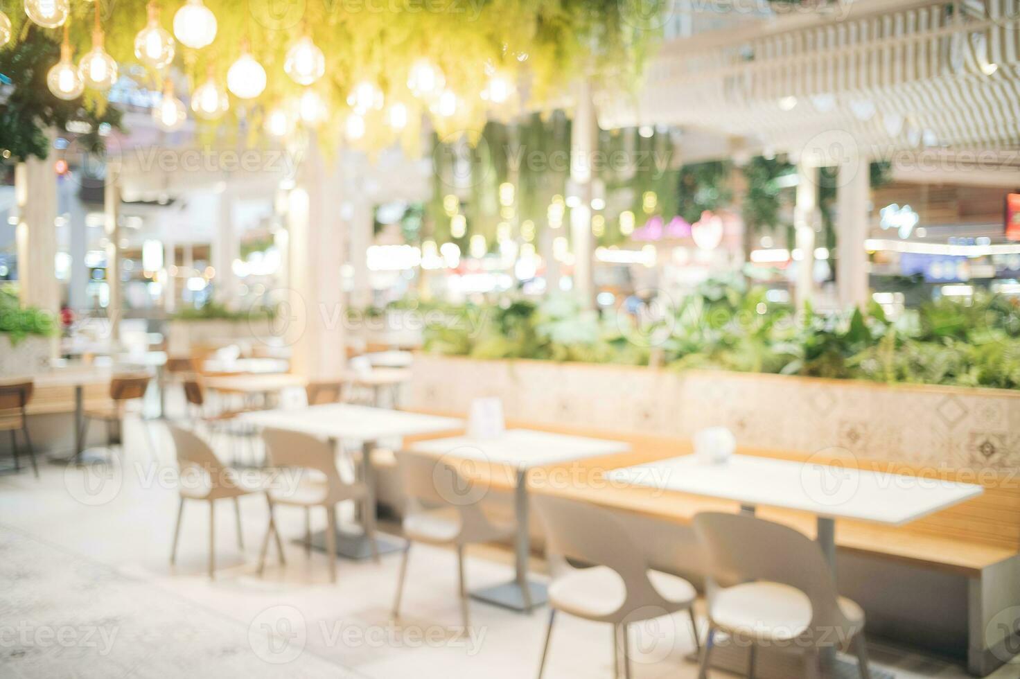 Blur bokeh background of interior table and chair in mall canteen. Abstract bokeh of food business dining court with no person. Defocused of light retail lifestyle cafe shop decoration in modern. photo