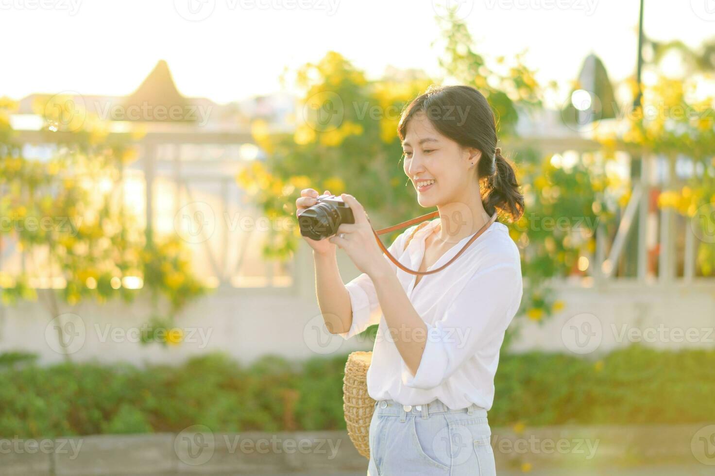 retrato de asiático mujer viajero utilizando cámara a calle de bangkok, tailandia Asia verano turismo vacaciones concepto foto