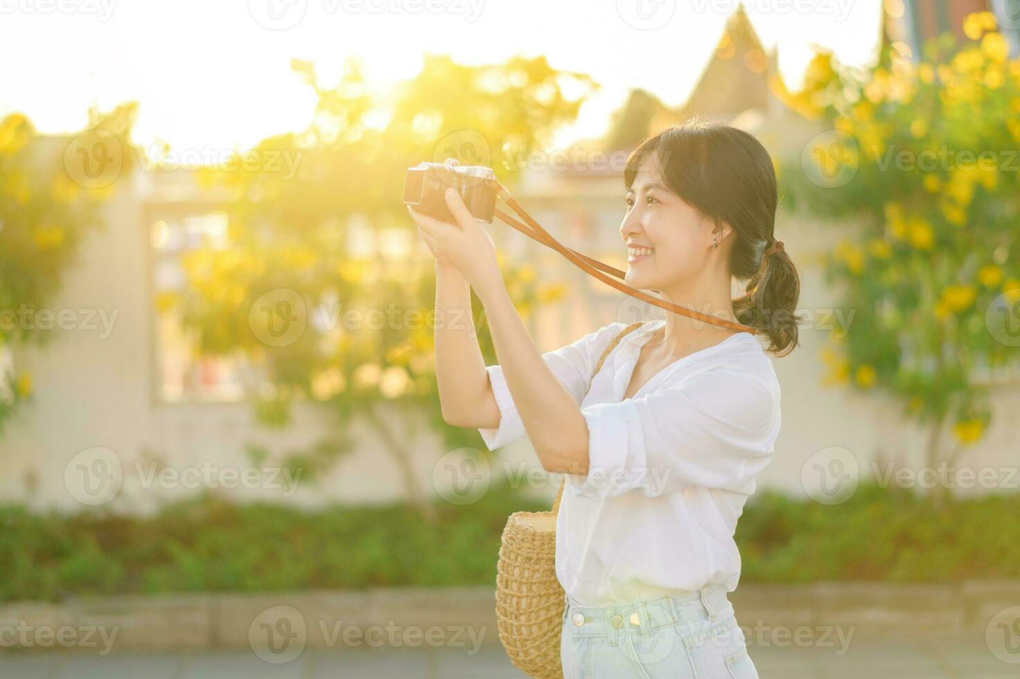Portrait of asian woman traveler using camera at street of Bangkok, Thailand. Asia summer tourism vacation concept photo