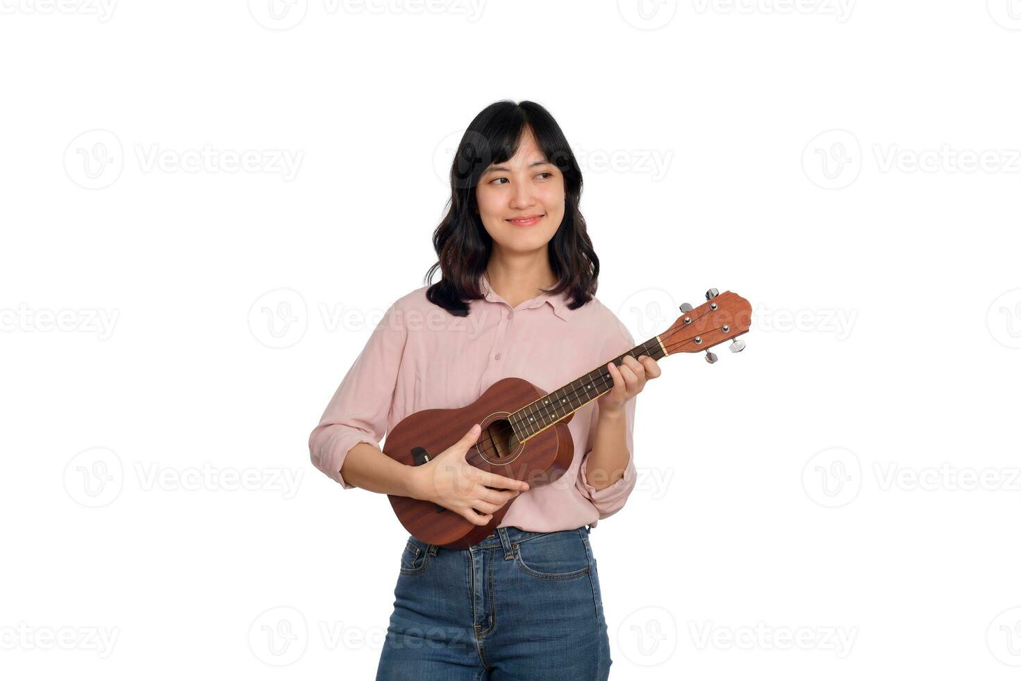 contento joven asiático mujer con casual ropa jugando ukelele aislado en blanco antecedentes foto