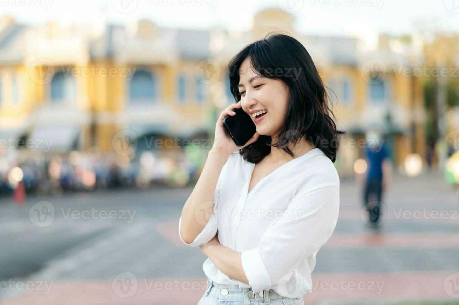 Portrait beautiful young asian woman with smart mobile phone around outdoor street view in a summer day photo