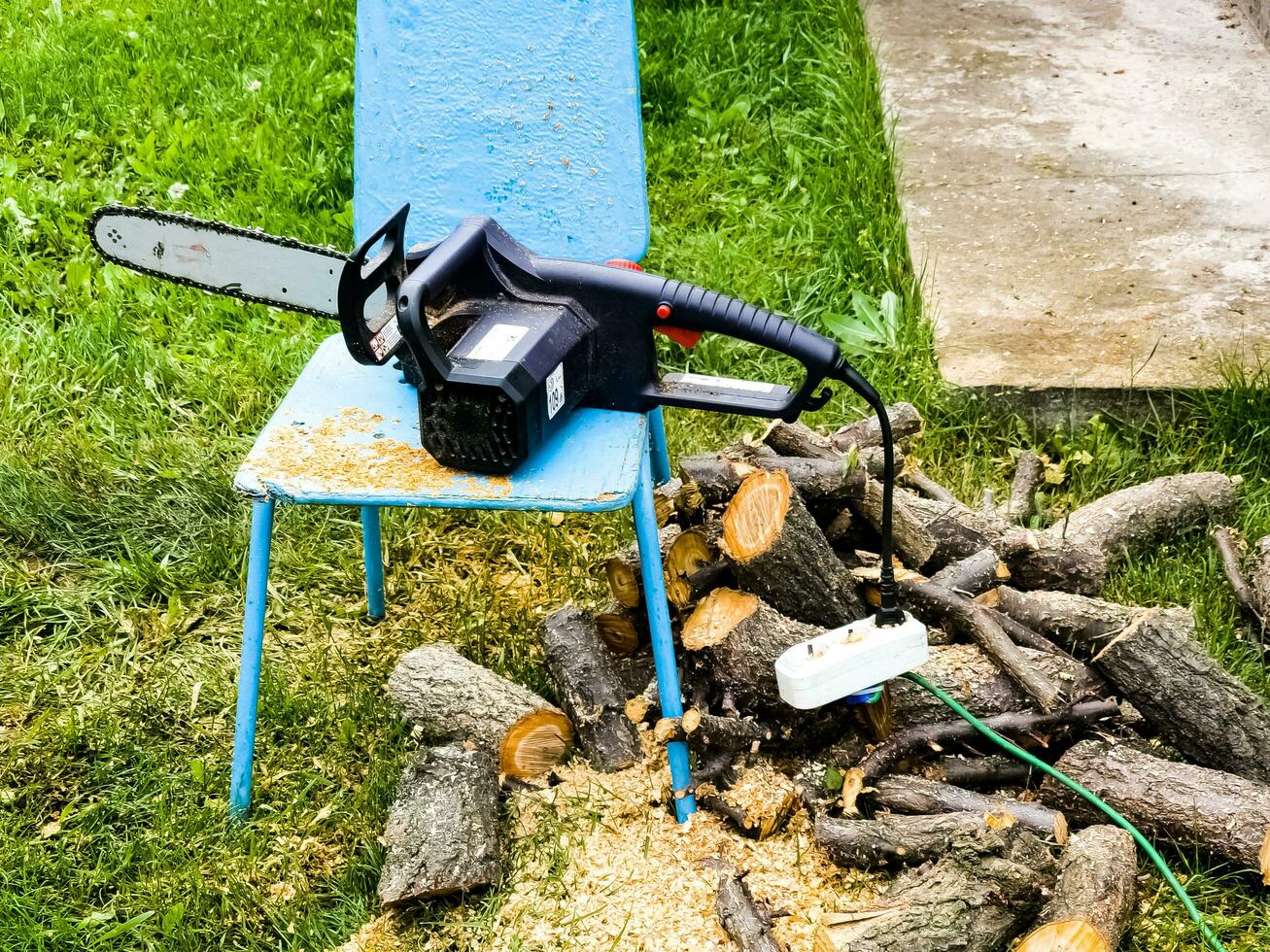 eléctrico cadena Sierra y aserrado madera durante estacional trabajando en  el jardín y corte arboles para leña. 24522497 Foto de stock en Vecteezy
