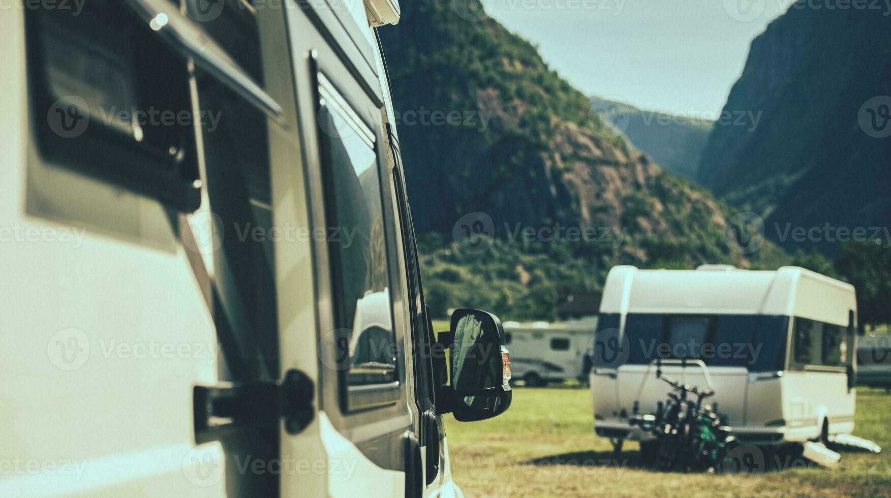 Camper Van and A Travel Trailer in a Background Staying Inside a RV Park photo