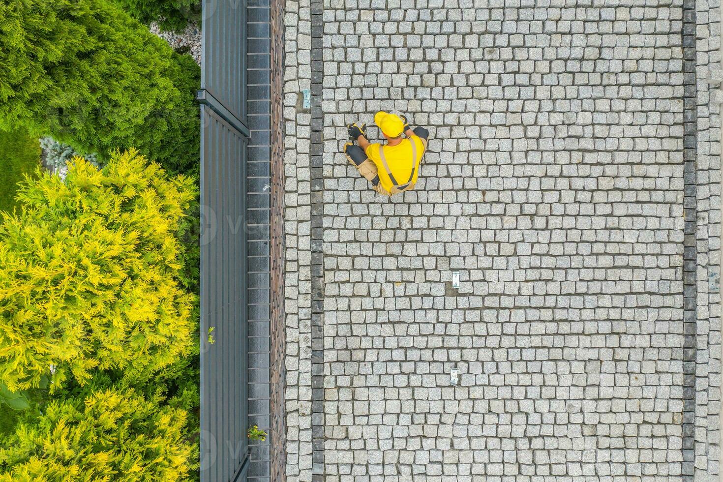 Construction Worker Finishing Building the Granite Brick Driveway photo