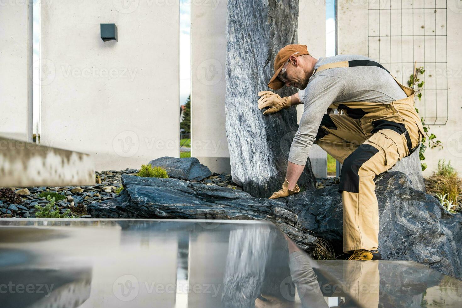 Landscaper Building Rockery Garden Using Large Granite Stones photo