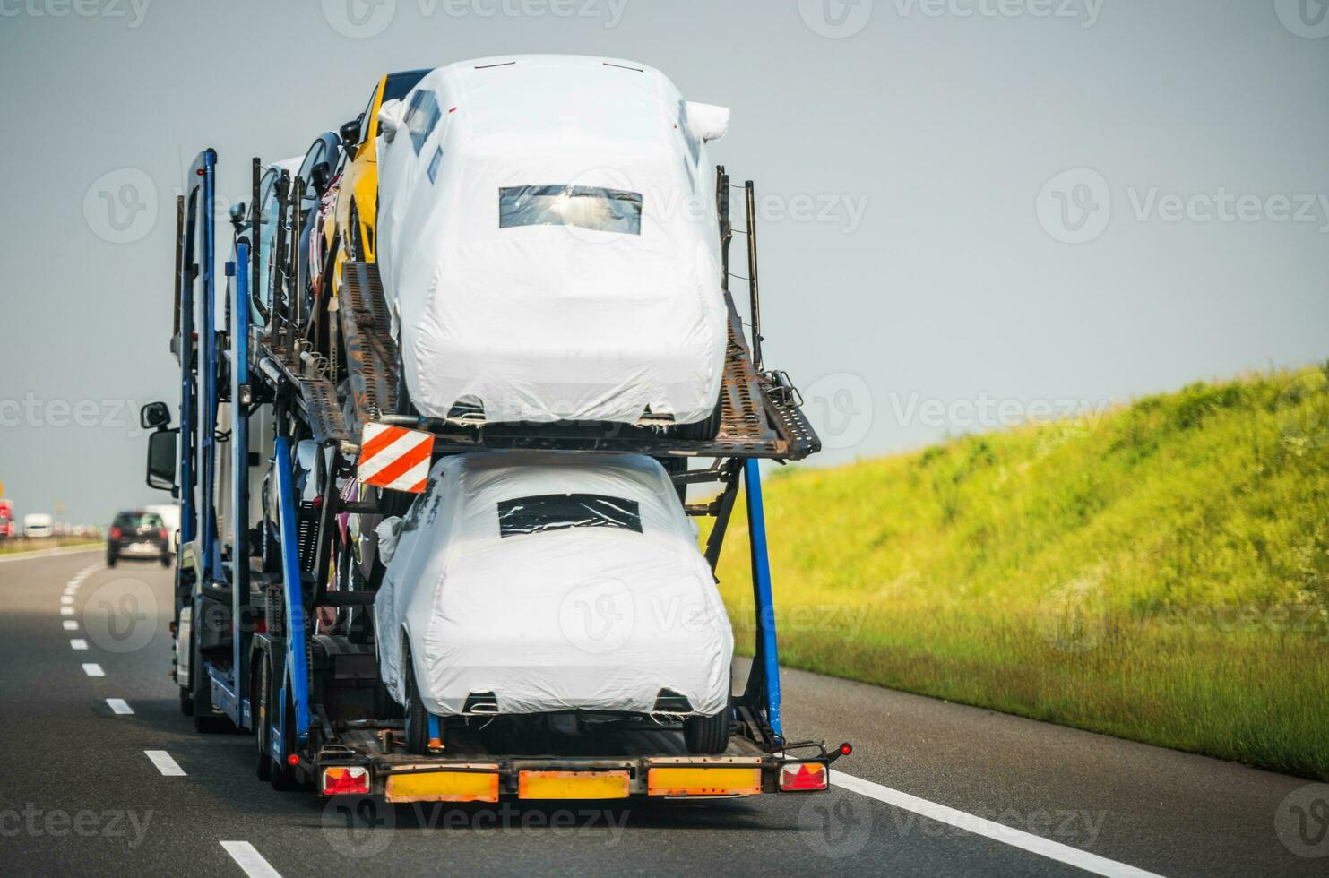 Car Carrier Trailer Full of Vehicles Driving Down the Highway photo