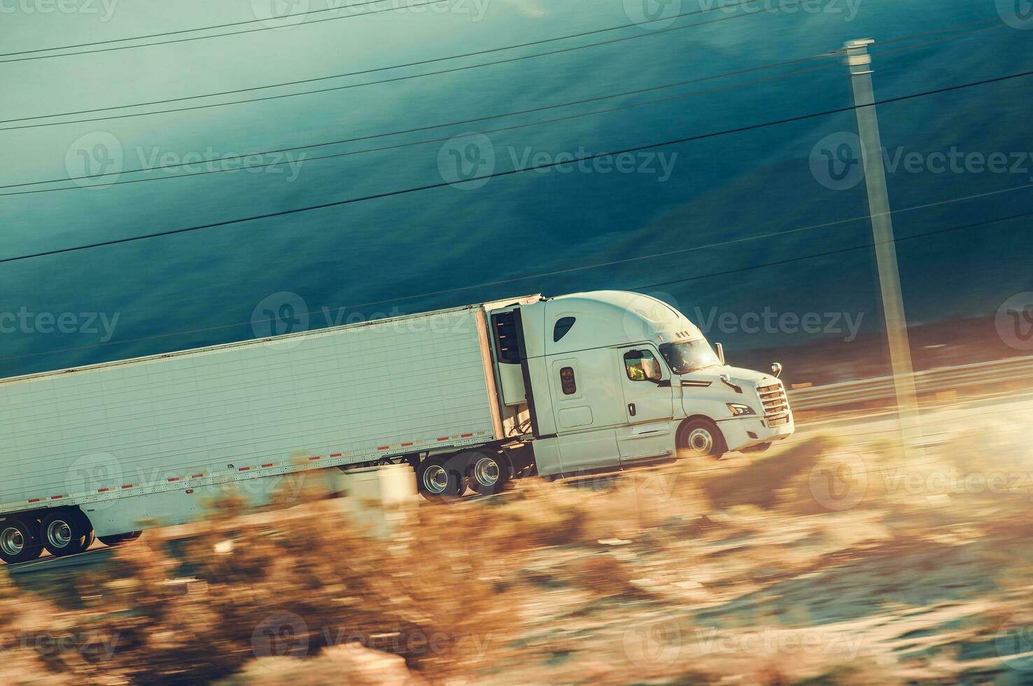 Speeding Modern Semi Trailer Truck on a Desert Highway photo