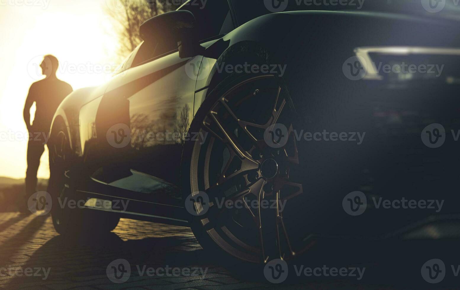 Driver and His Performance Car During Sunset photo