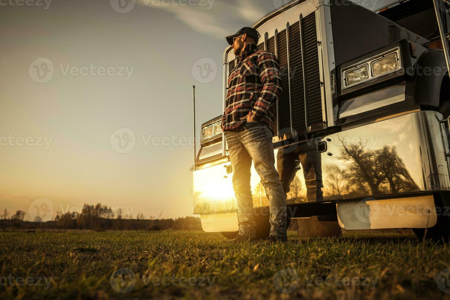 Trucker in Front of His Semi Truck During Sunset photo