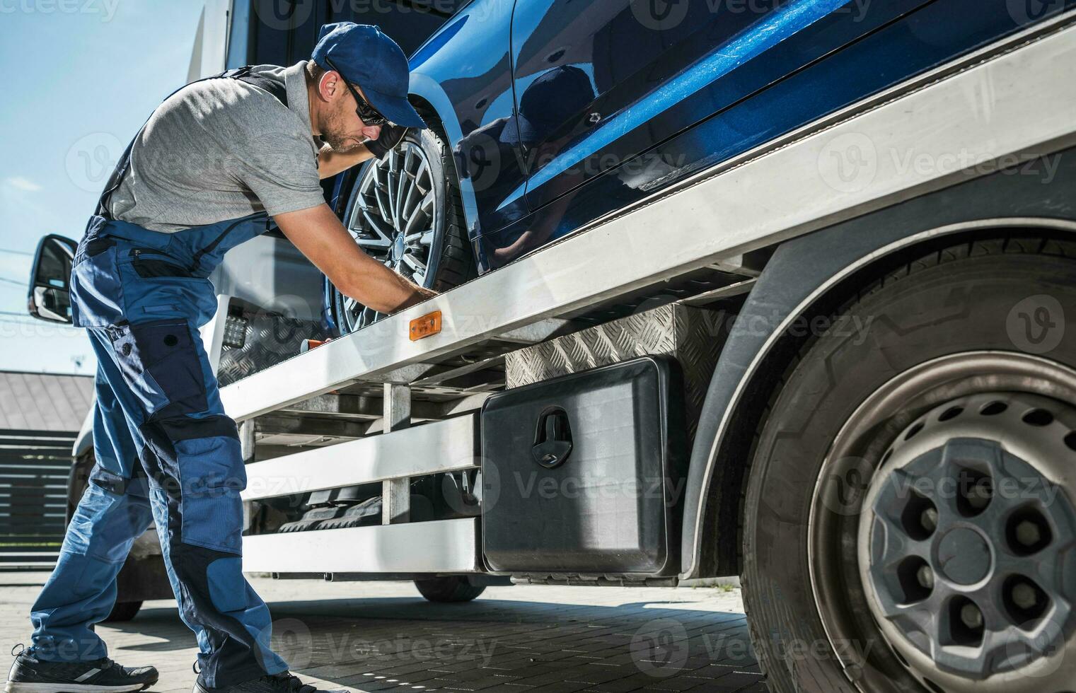 Tow Man Making Sure the Car is Secured for Transport photo