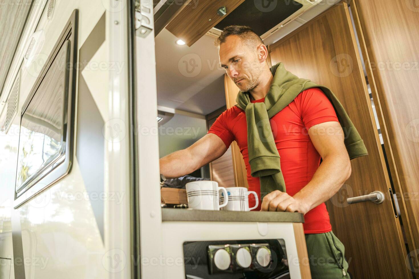 Man Preparing Hot Drinks Inside His RV Camper Van photo