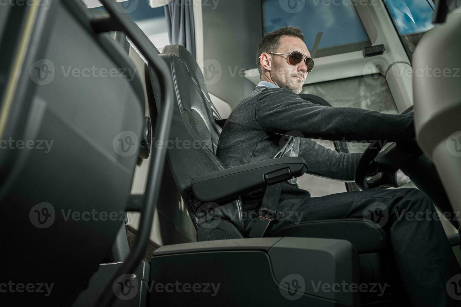 Caucasian Male Coach Bus Driver Behind Vehicle Wheel photo