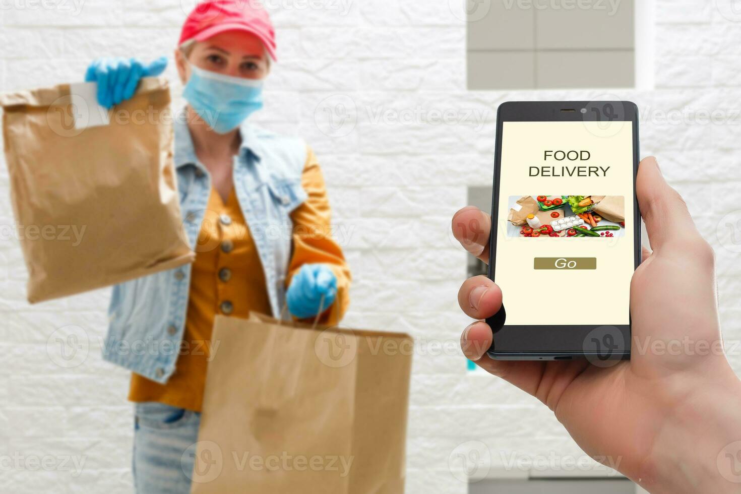 delivery food service at home. Man courier delivered the order no name bag with food. Hand holding smart phone with food online device on screen photo