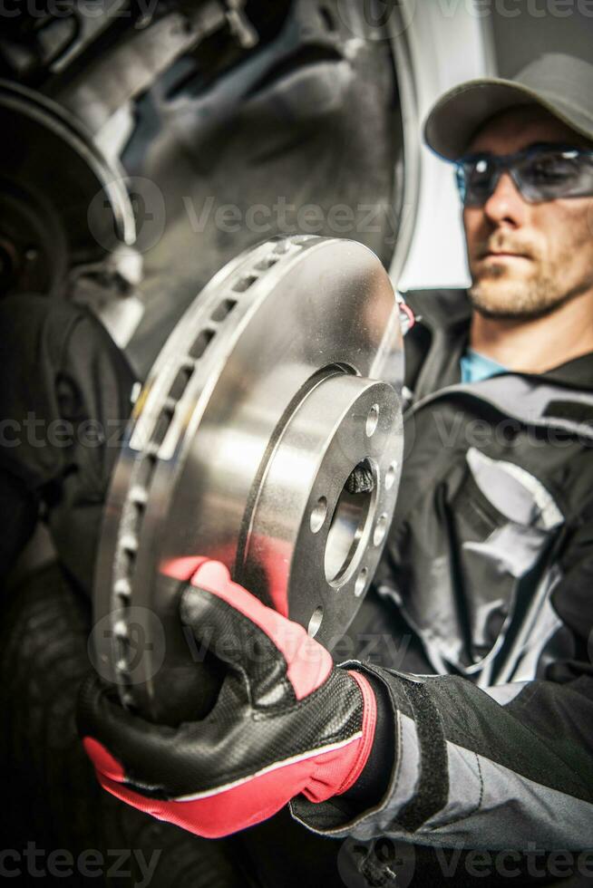 Car Mechanic Replacing Car Disc Brakes. photo