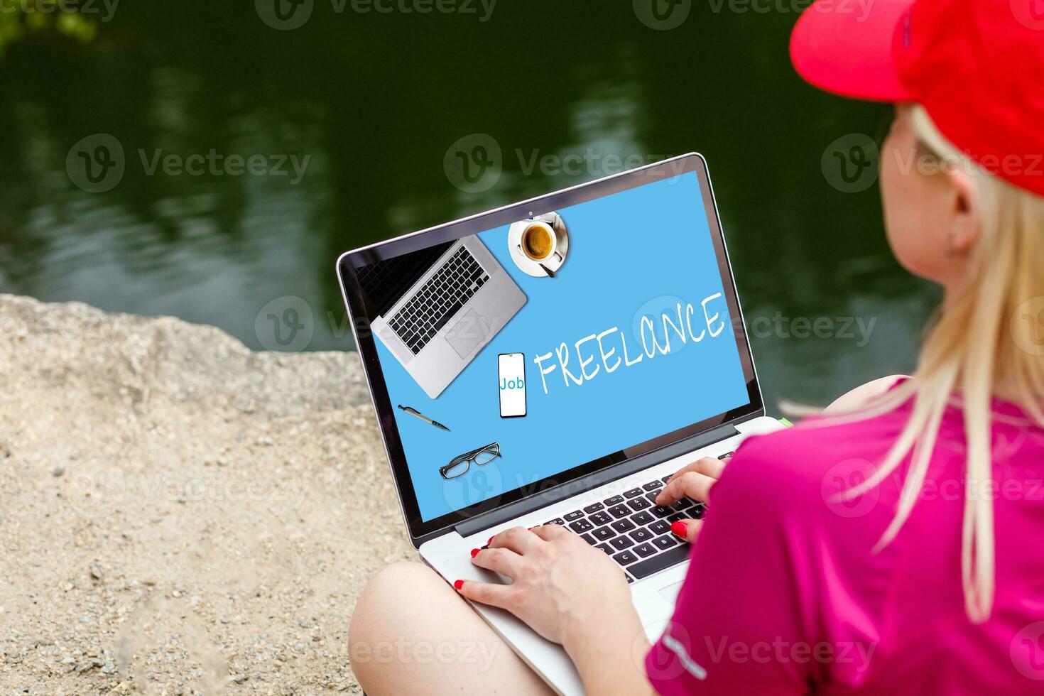 Attractive blonde hair woman working with a laptop on the seashore and look to the laptop. Female freelancer working near the sea. photo