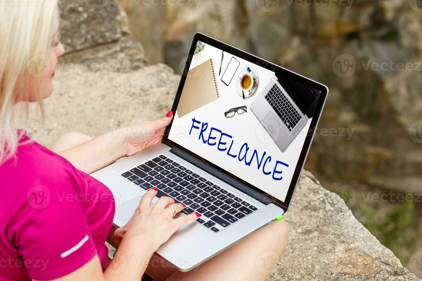 Attractive blonde hair woman working with a laptop on the seashore and look to the laptop. Female freelancer working near the sea. photo