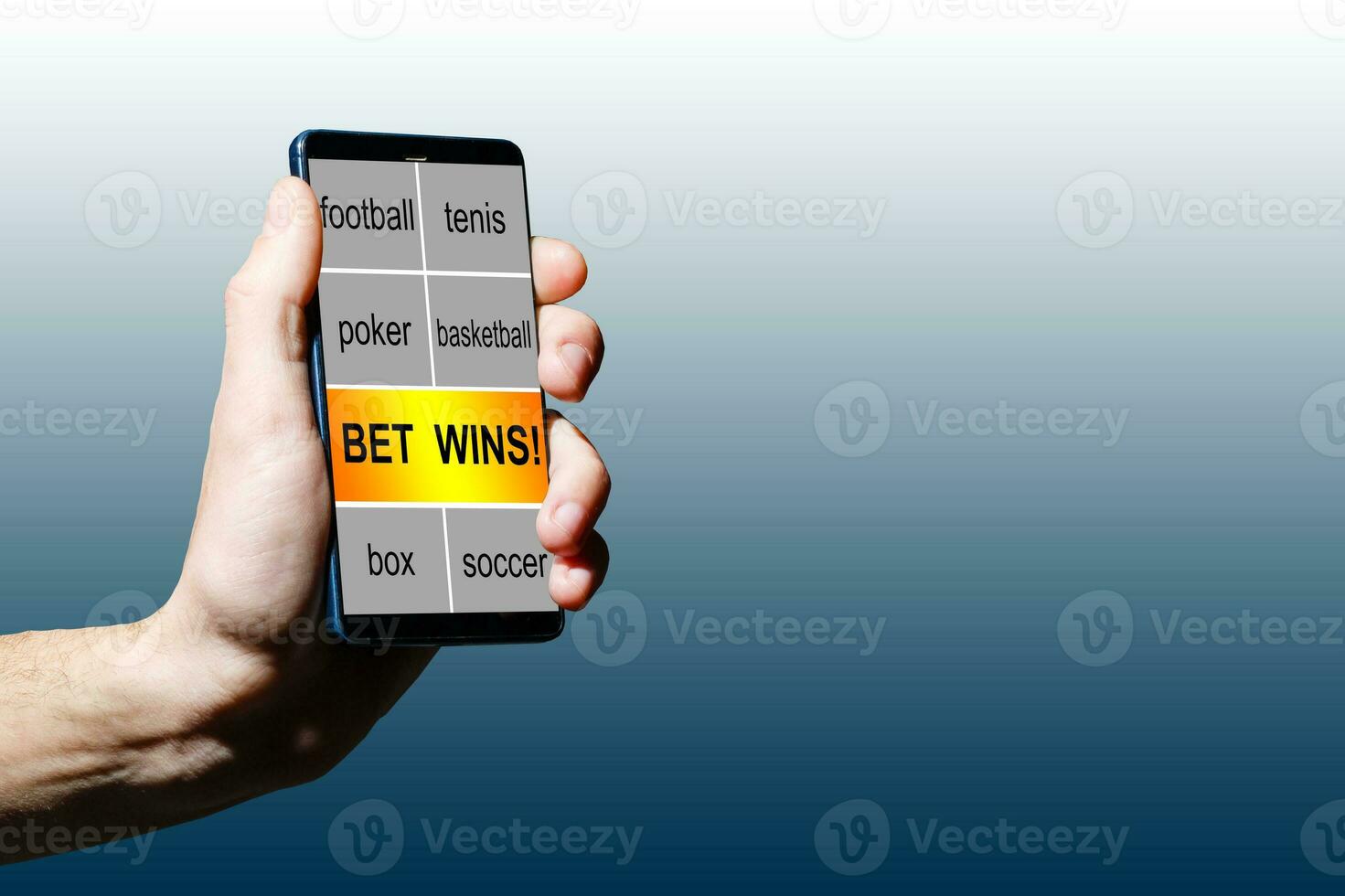 Close up cropped shot of male hands making bets using gambling mobile application on his phone. Man watching football match online broadcast on his laptop waiting for winning results. photo