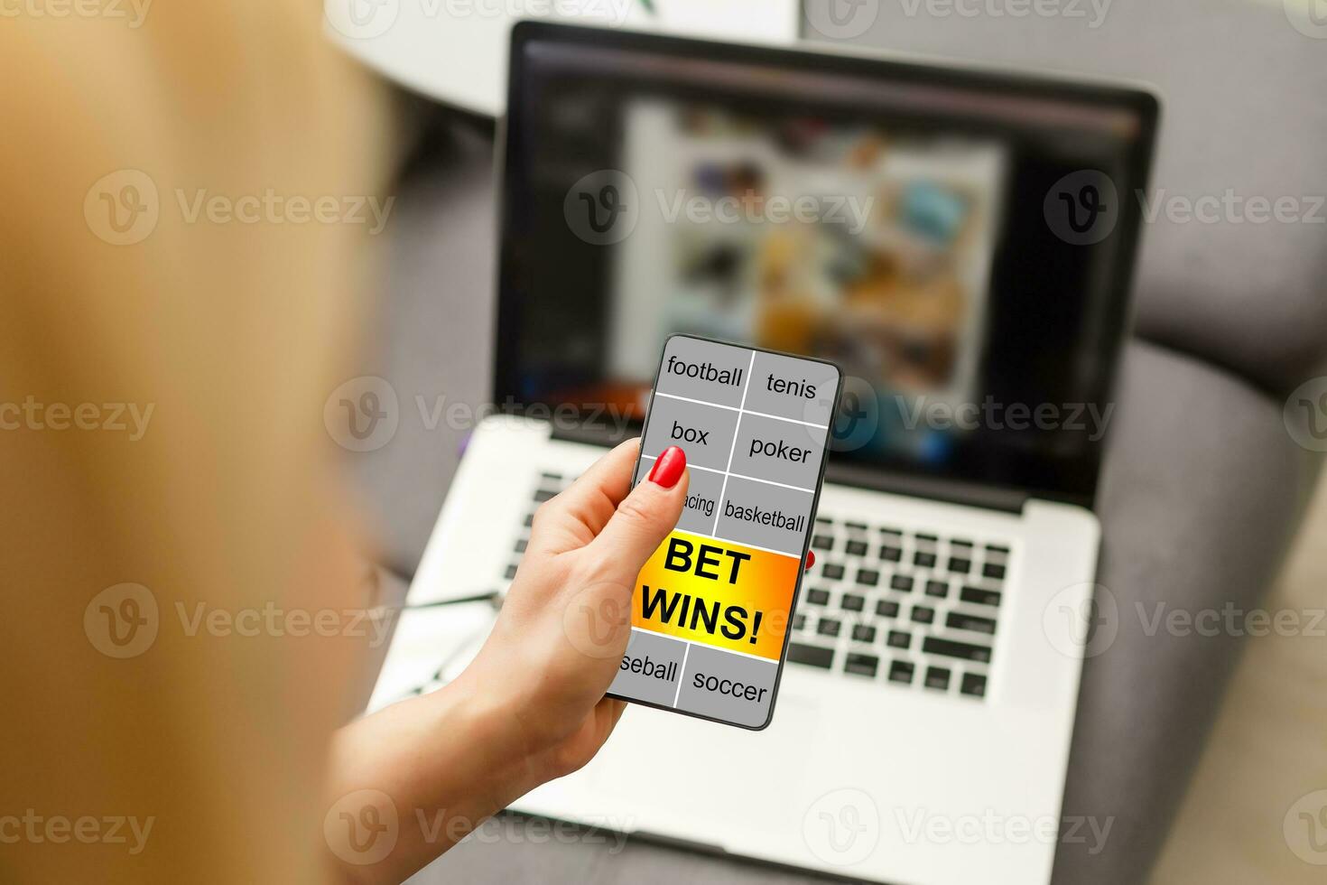 Close up cropped shot of female hands holding smartphone with bookmaker's website on a screen. Young woman placing sport bets online using mobile application. photo