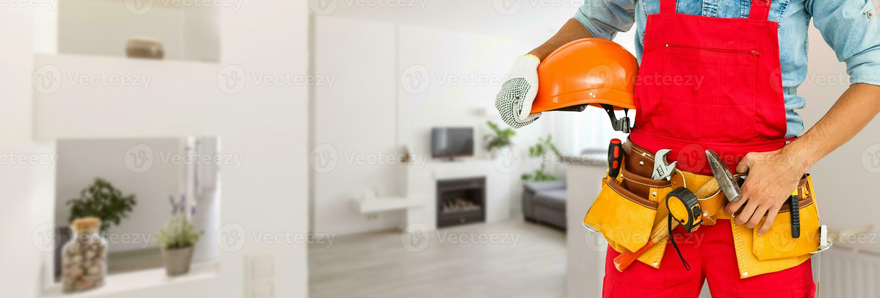 joven trabajador pintando la pared en la habitación foto