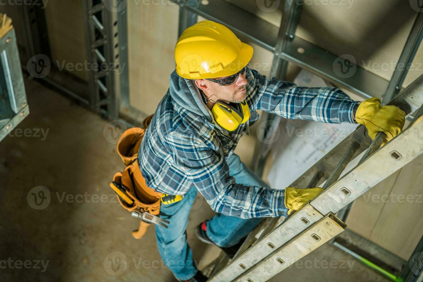 Construction Worker Using Extension Ladder photo