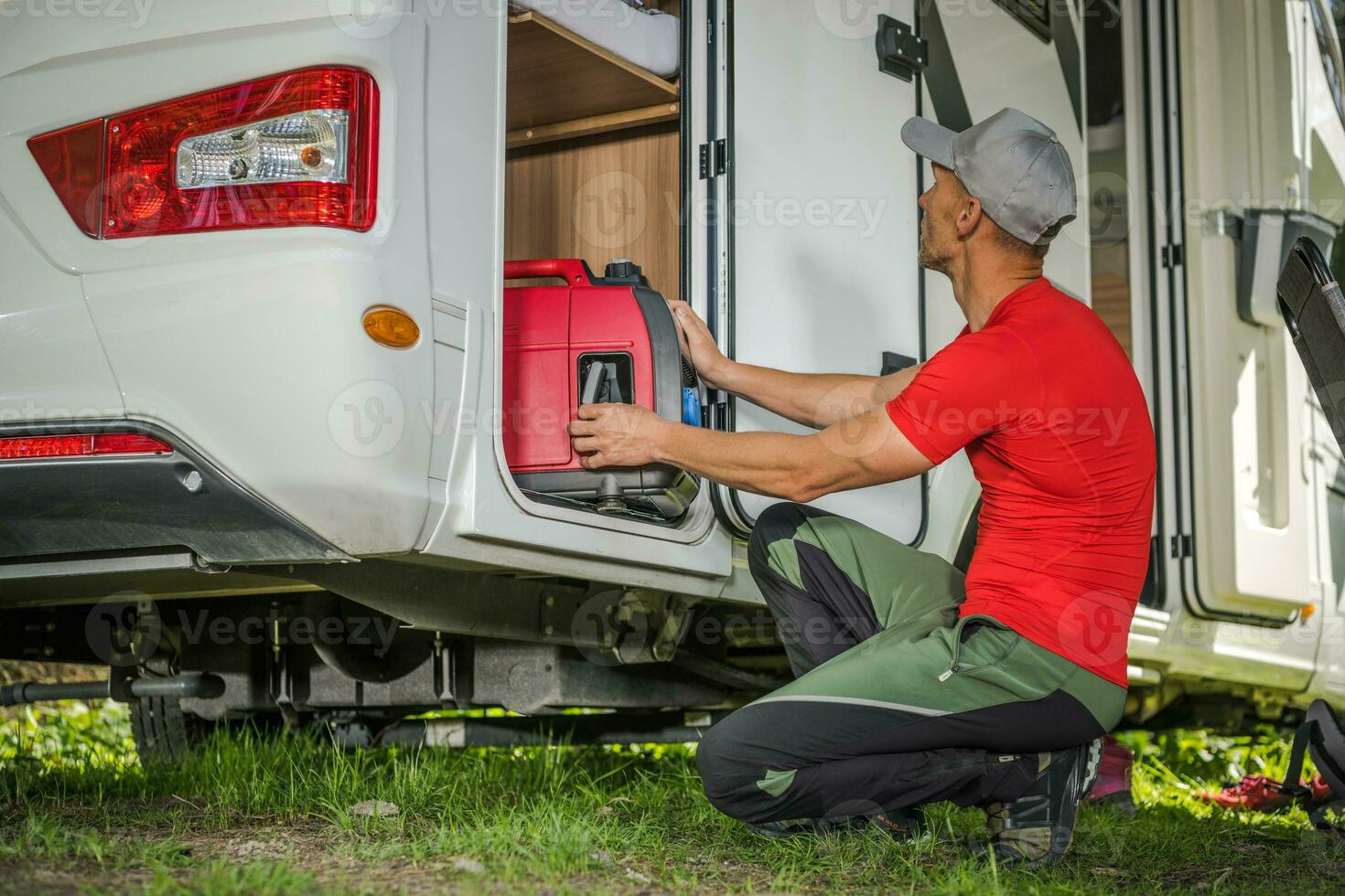 Men Removing Portable Gas Generator From His Camper Van RV Storage Area photo