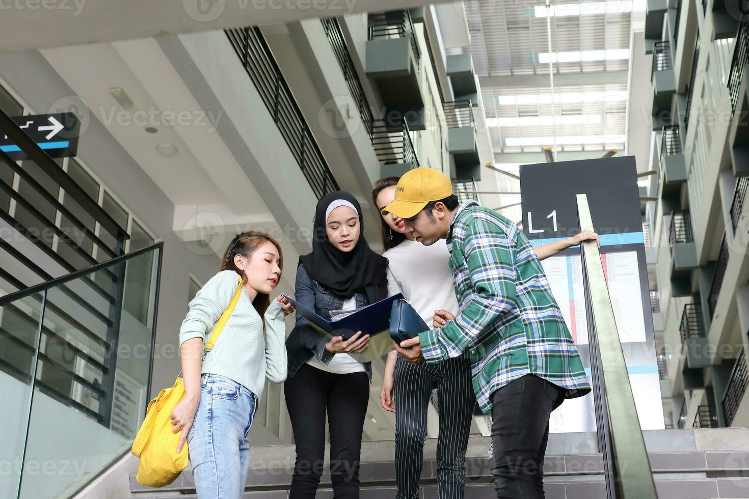 Young asian malay chinese man woman indoor stair corridor campus book file folder laptop computer phone sit stand study mingle photo