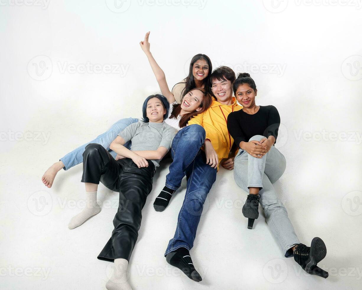 Group of young south east asian mixed race man woman chinese malay indian sit lying pose on floor enjoy relax fun talk gather pose students colleagues look at camera photo