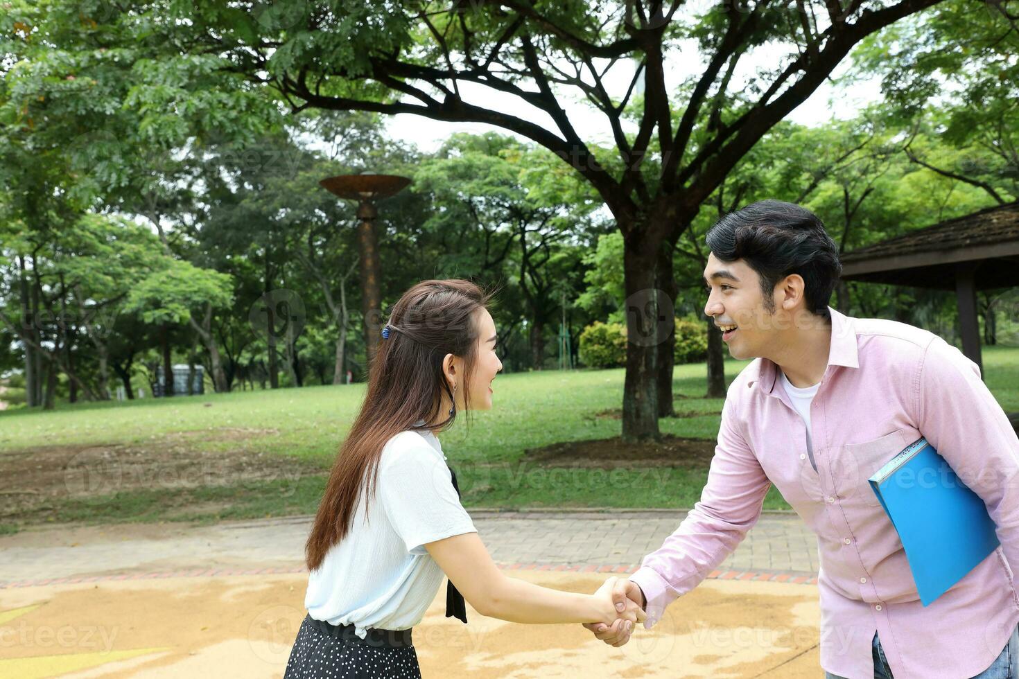 young asian malay chinese man woman outdoor park walk stand study talk discuss laptop file book backpack pose meet handshake photo