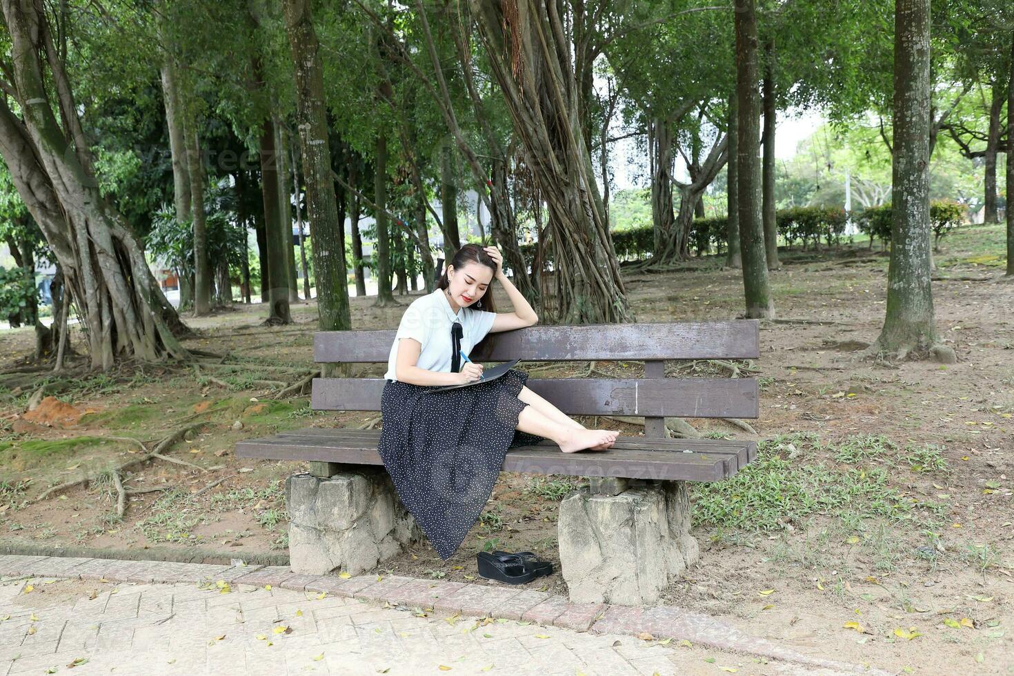 Young asian chinese woman outdoor park campus book file folder laptop computer phone sit stand study mingle photo