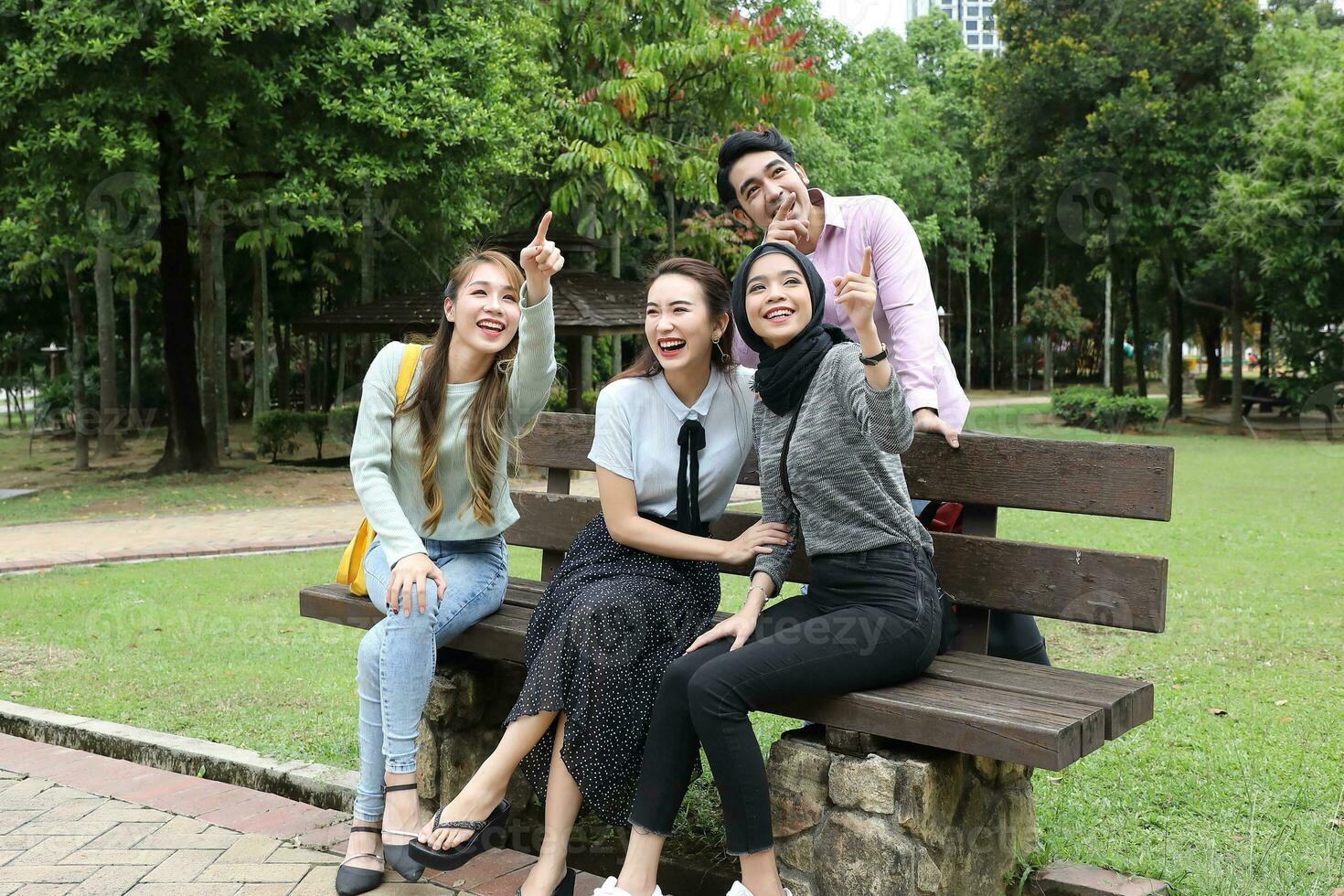 Young asian malay chinese man woman outdoor park  book file folder laptop computer phone sit stand study mingle photo