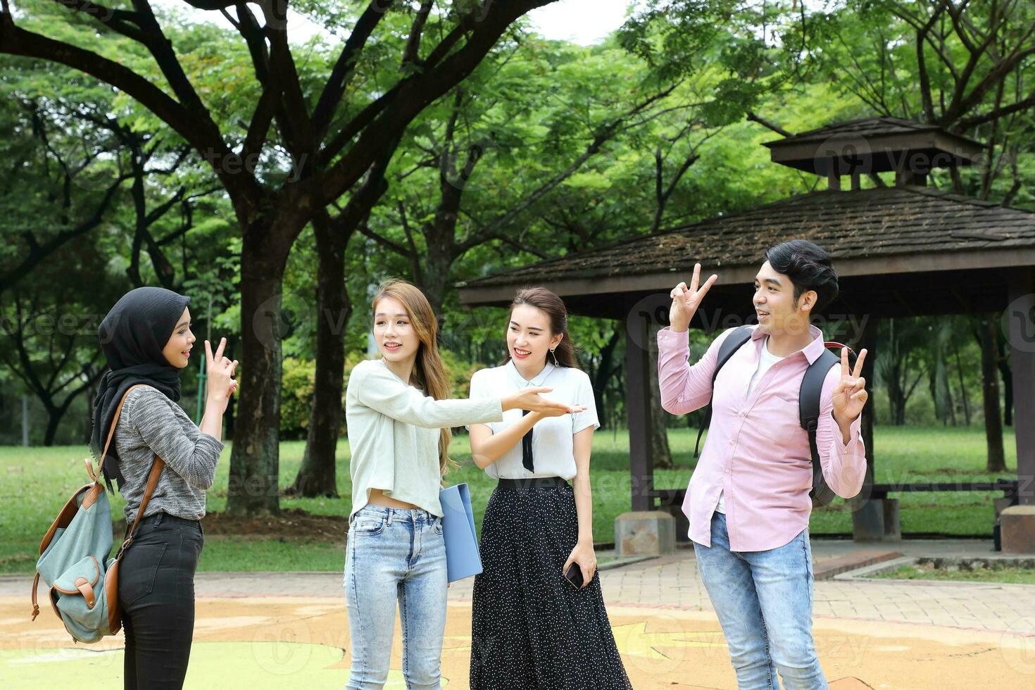 Young asian malay chinese man woman outdoor park  book file folder laptop computer phone sit stand study mingle photo