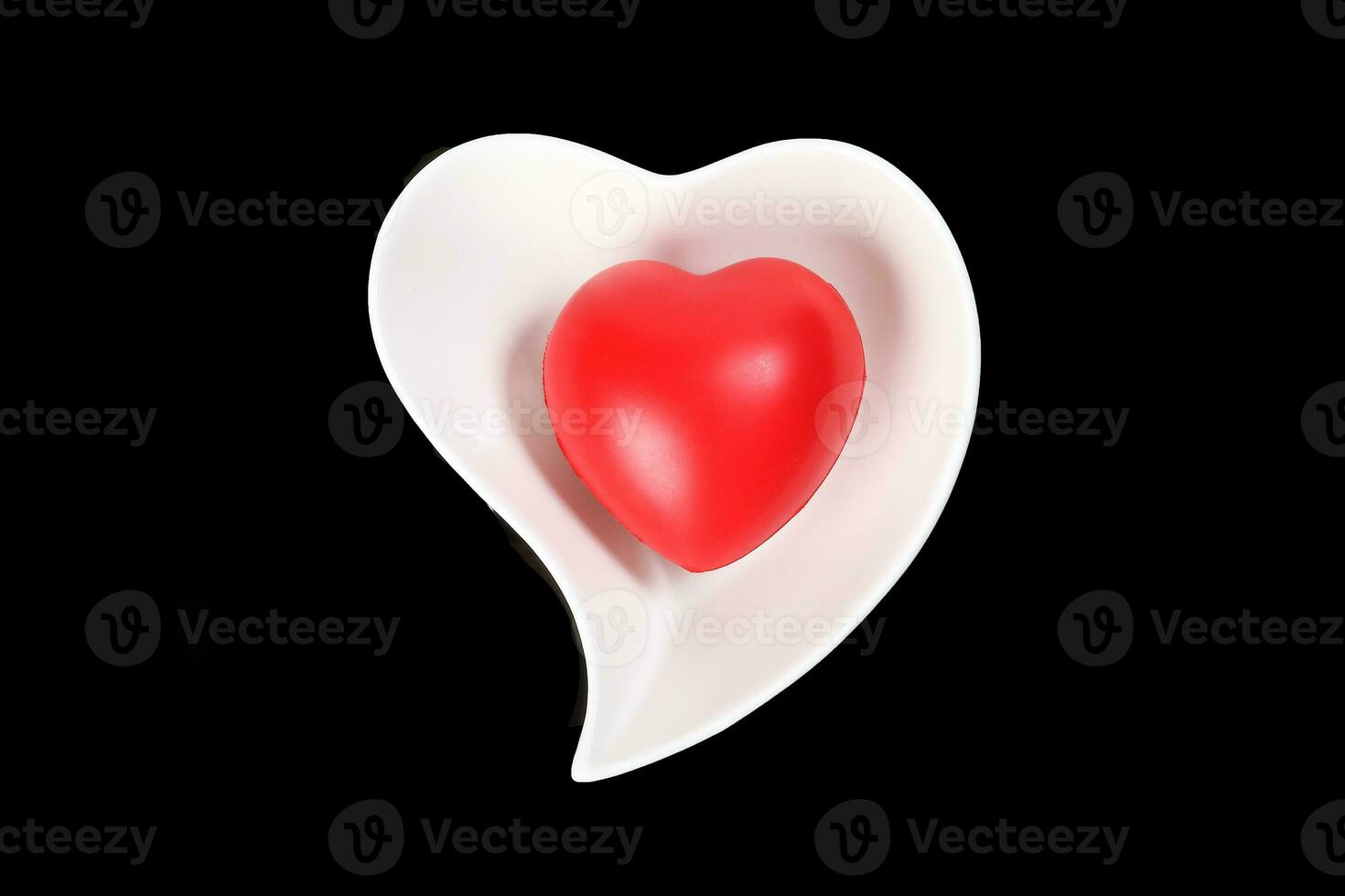 Hart Love shape plastic rubber object on white plate black background photo
