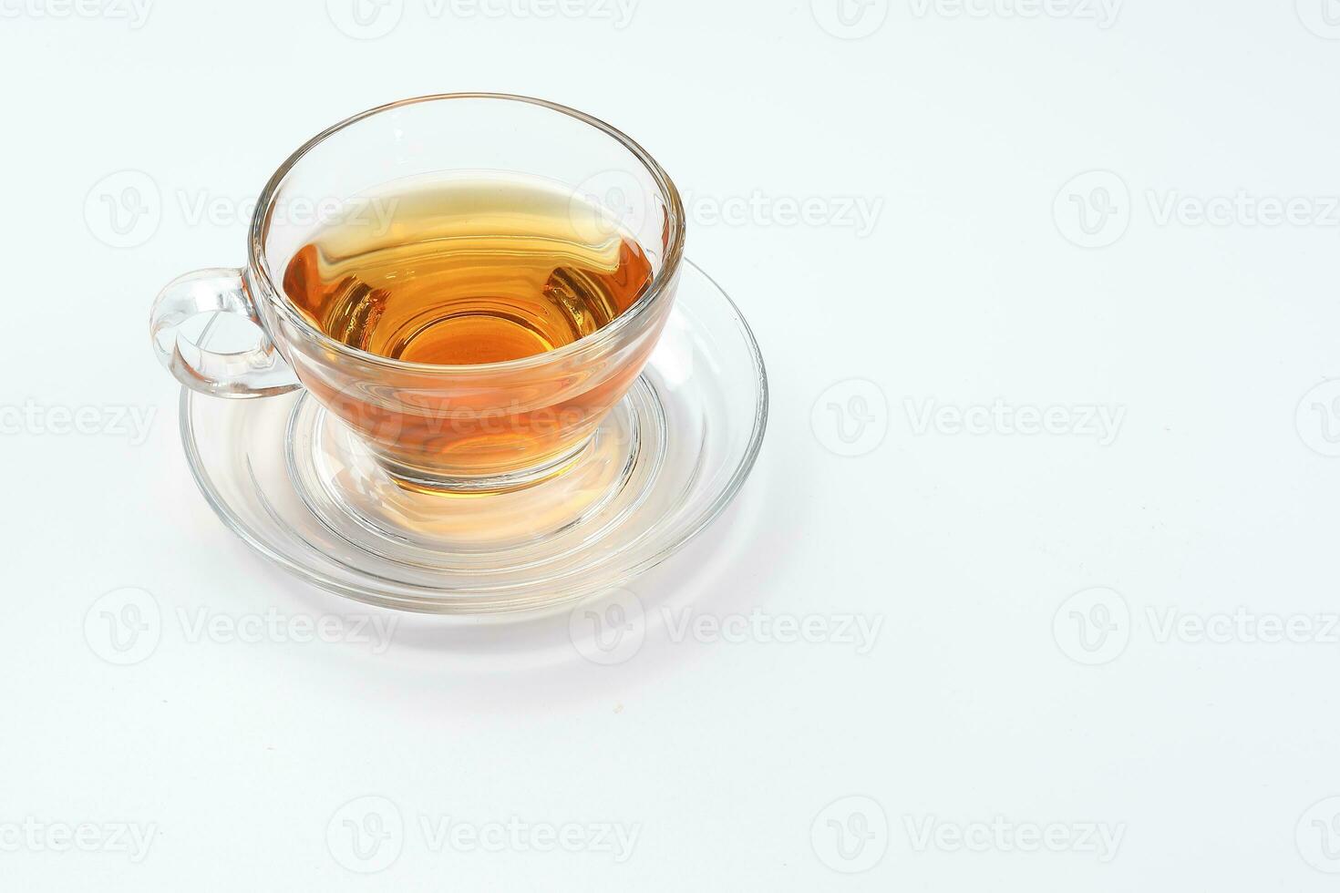 Clear licker tea in a transparent glass cup saucer spoon on white background photo