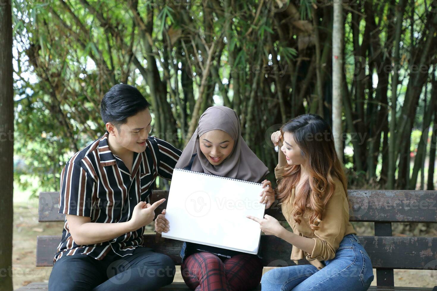 Young Asian Malay man woman outdoor green park walk talk discuss mingle photo