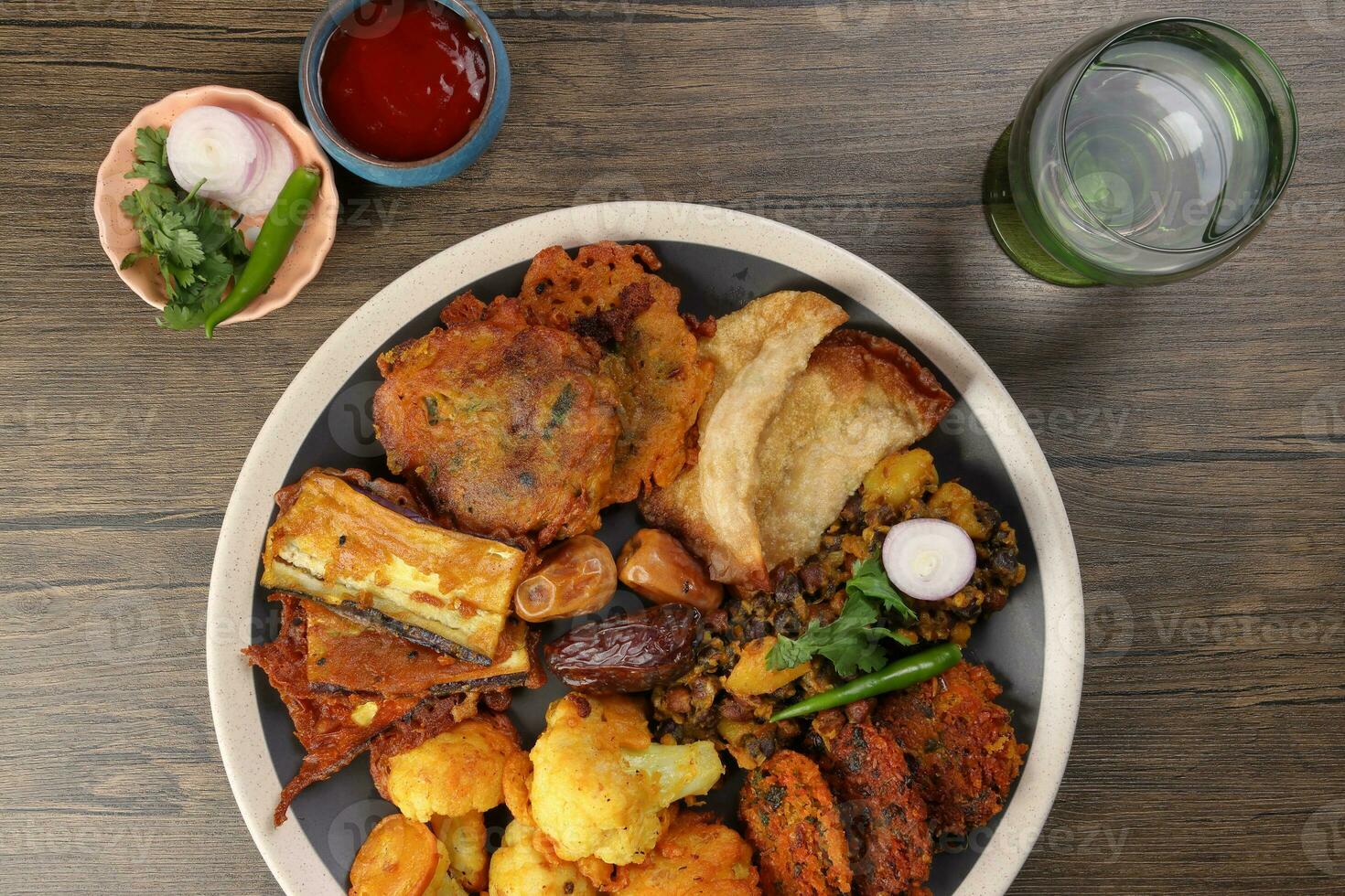 Indian Bengali stye variety fitter deep fried tanpura piaju pakoda battered cauliflower eggplant dumplings chola dal fry dates for iftar breakfast snack comfort food rustics wood background photo