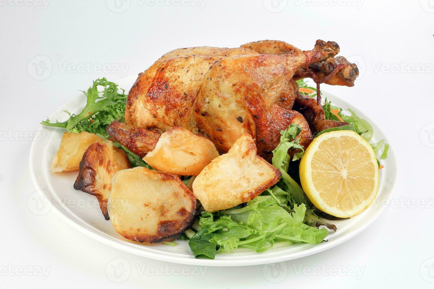 Whole roasted grilled chicken poultry bird with baked potato vegetable salad tomato lemon on white background photo