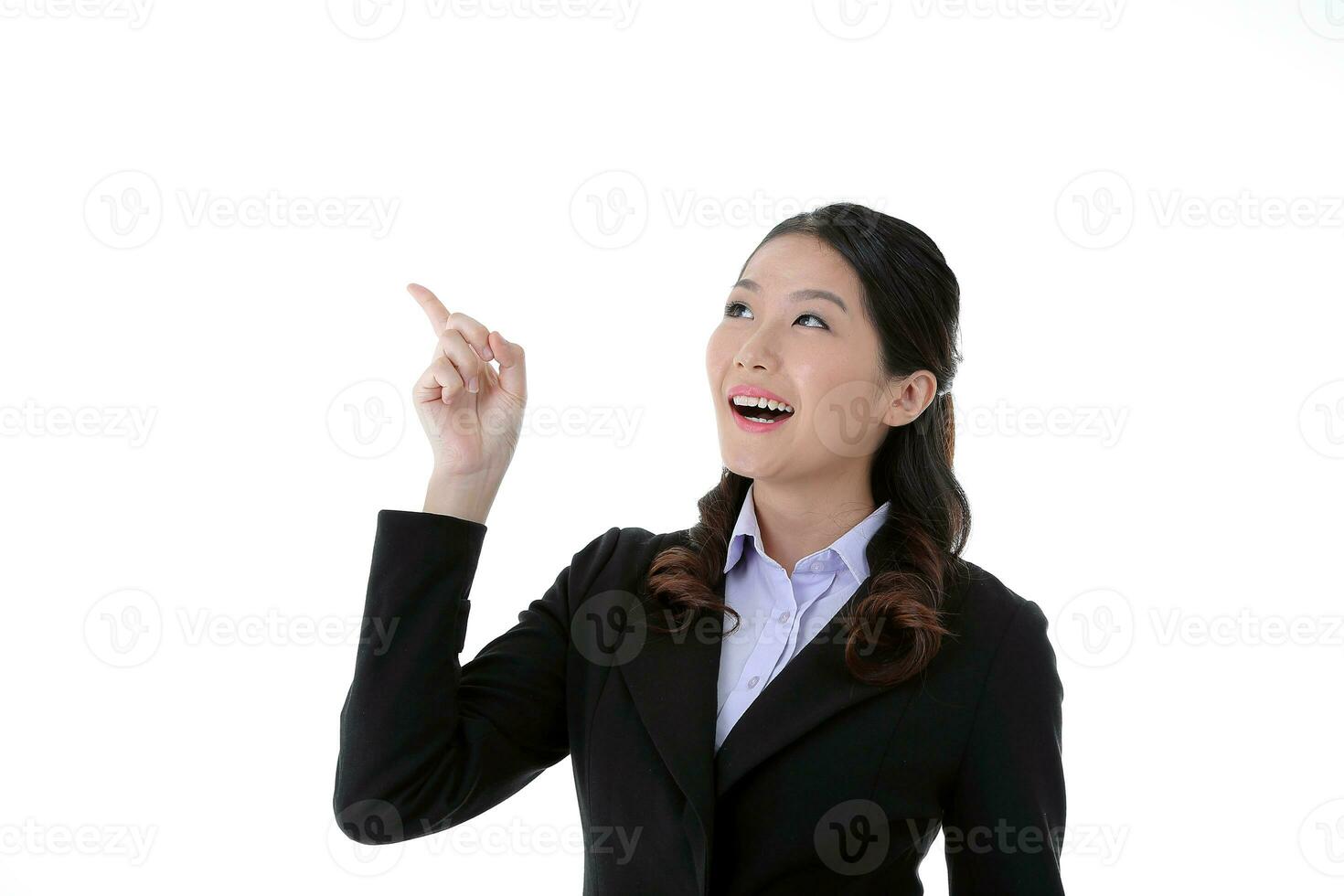 Southeast Asian young office business woman wearing suit point up happy smile expression on white studio background photo