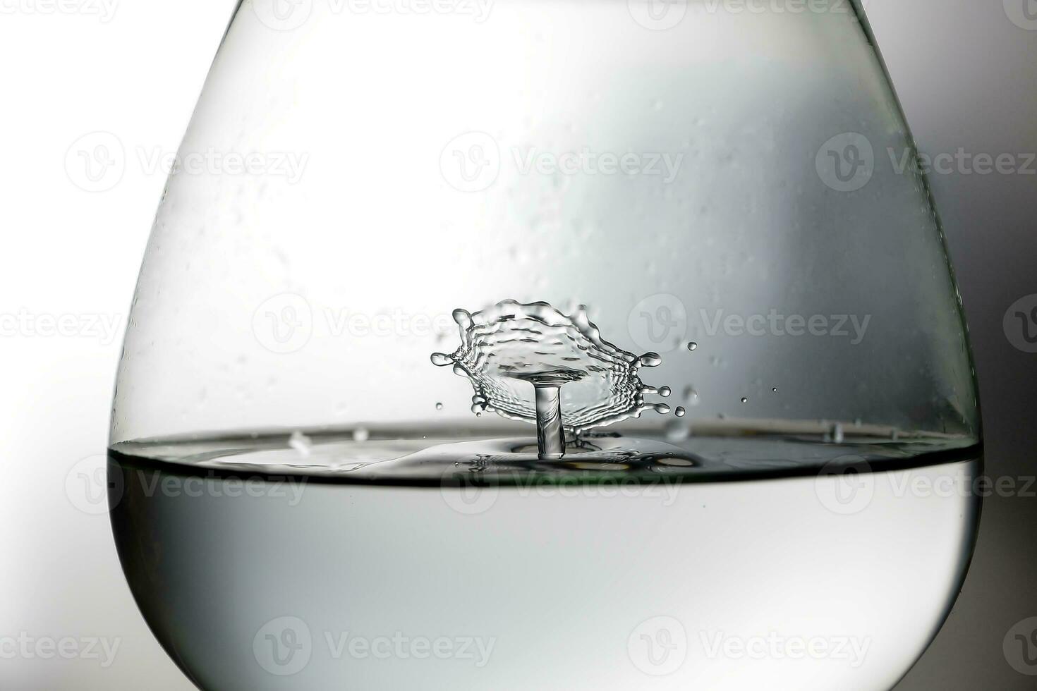 Water droplet drop splash collision dripping pillar reflection in brandy glass refraction photo
