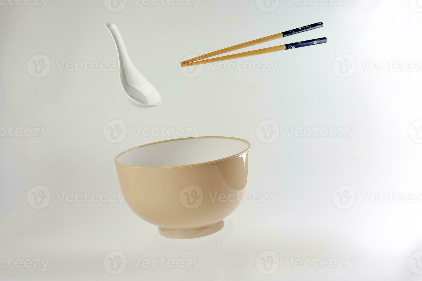 Empty oriental Japanese Chinese soup bowl spoon chopstick elevated flying in air off white photo