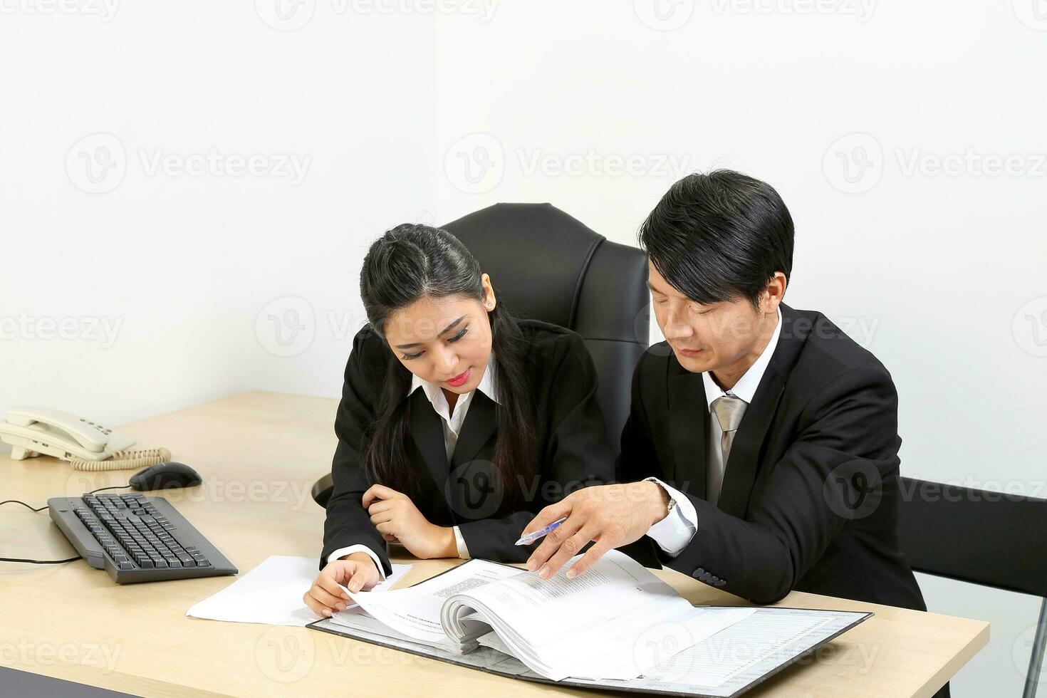 Young Asian male female wearing suit sitting at office desk thinking meeting disucsing sign document agreement photo